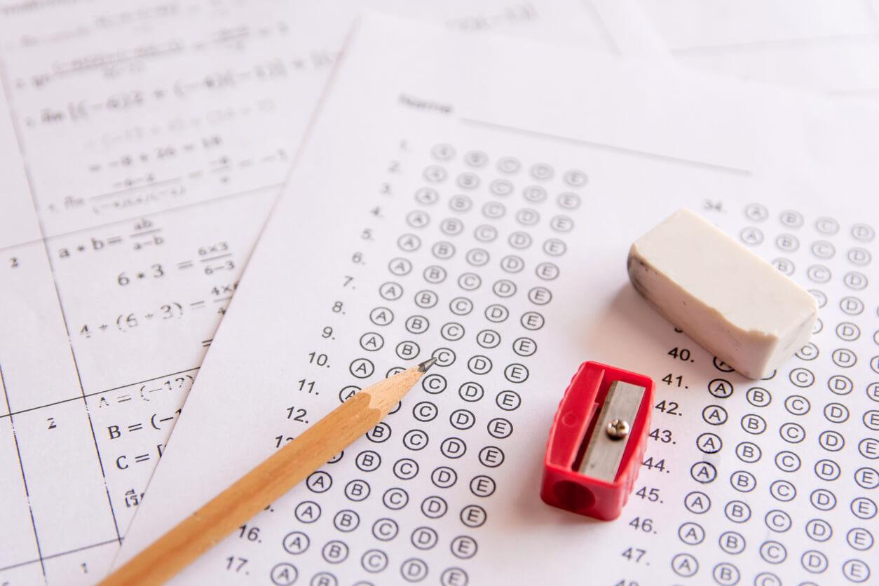 Pencil, Sharpener and eraser on answer sheets or Standardized test form with answers bubbled. multiple choice answer sheet