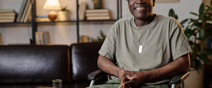 Mature african american war veteran with disability posing at therapist office smiling at camera